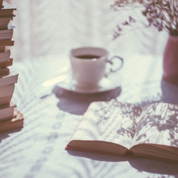 A mug of coffee and a book on a table