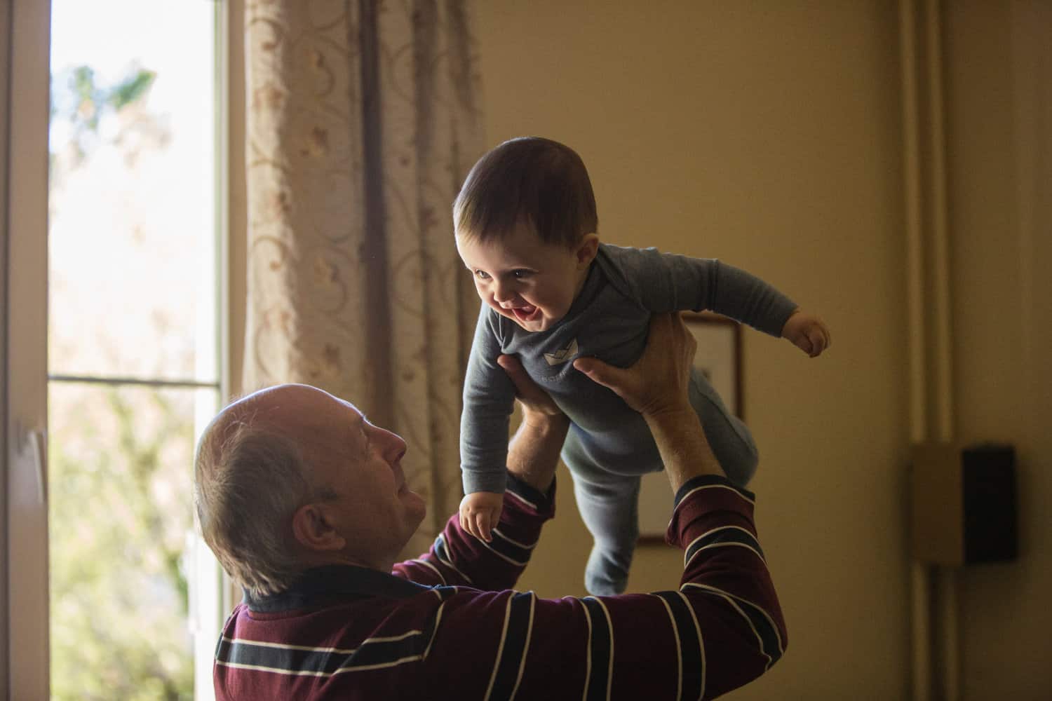 A grandpa holding up his grandchild