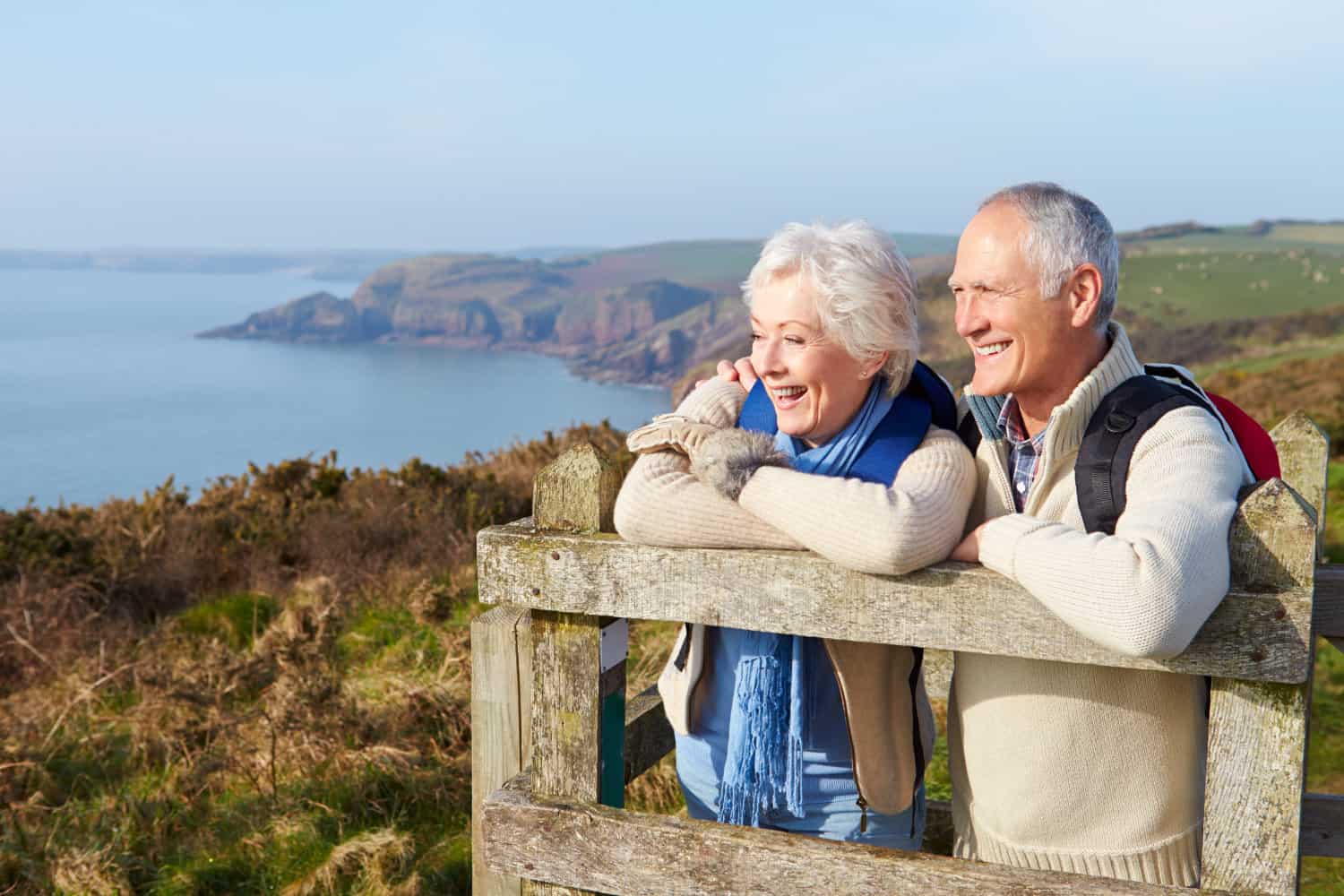 Retired couple overlooking a large body of water and hills