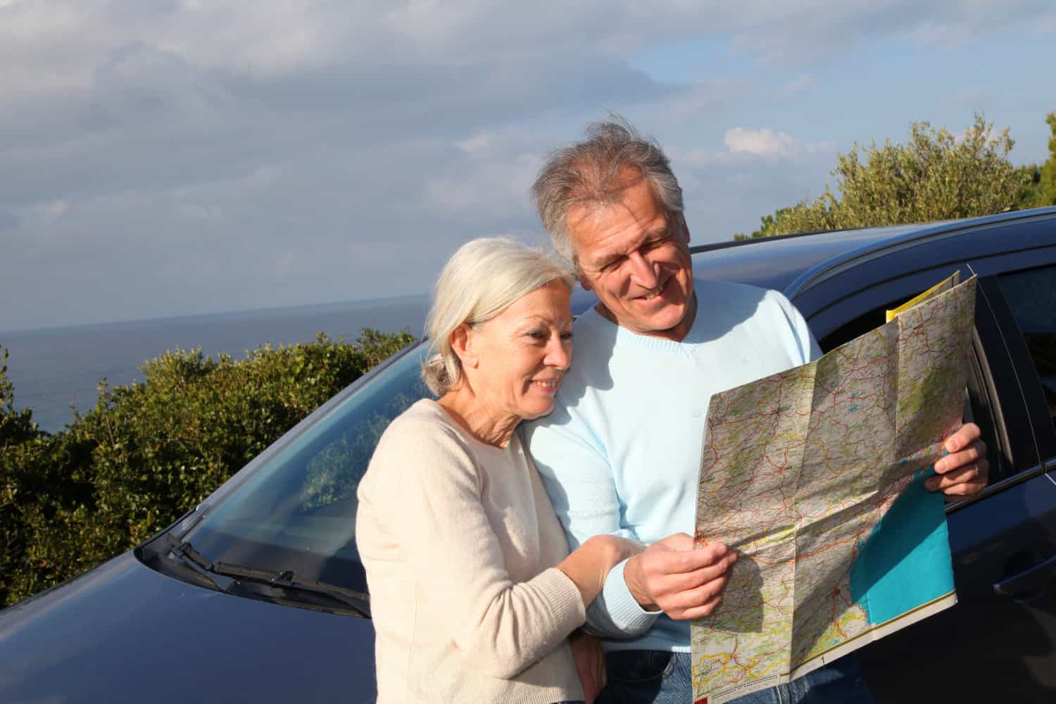 Retired couple reading a road map together