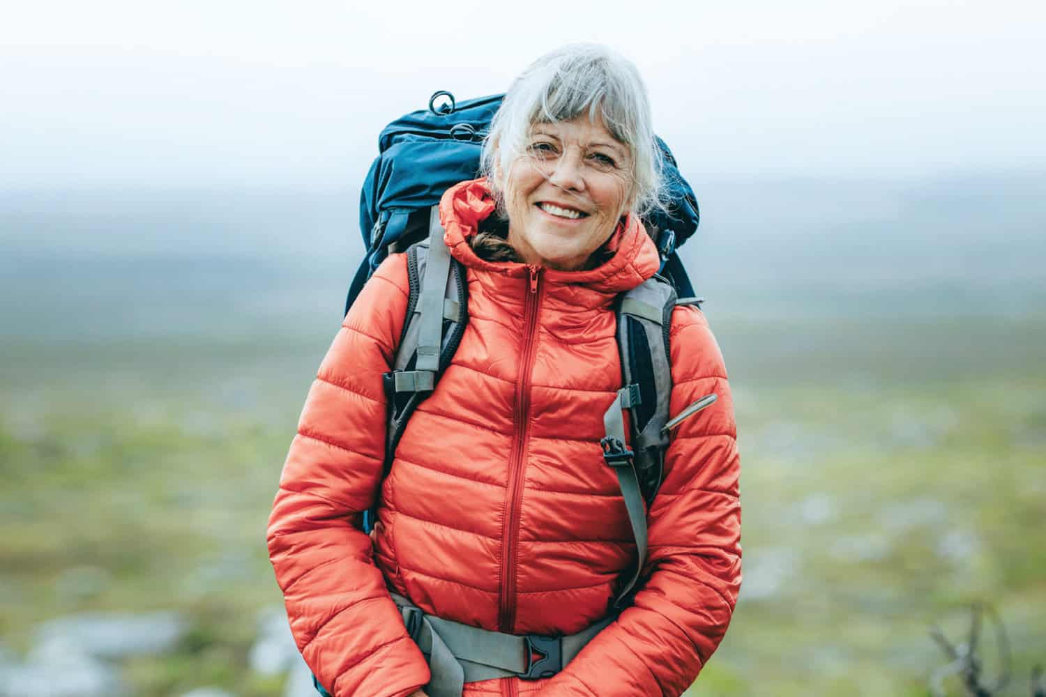 Retired woman smiling while hiking
