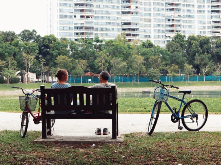 A couple sitting on a bench in a park in Singapore