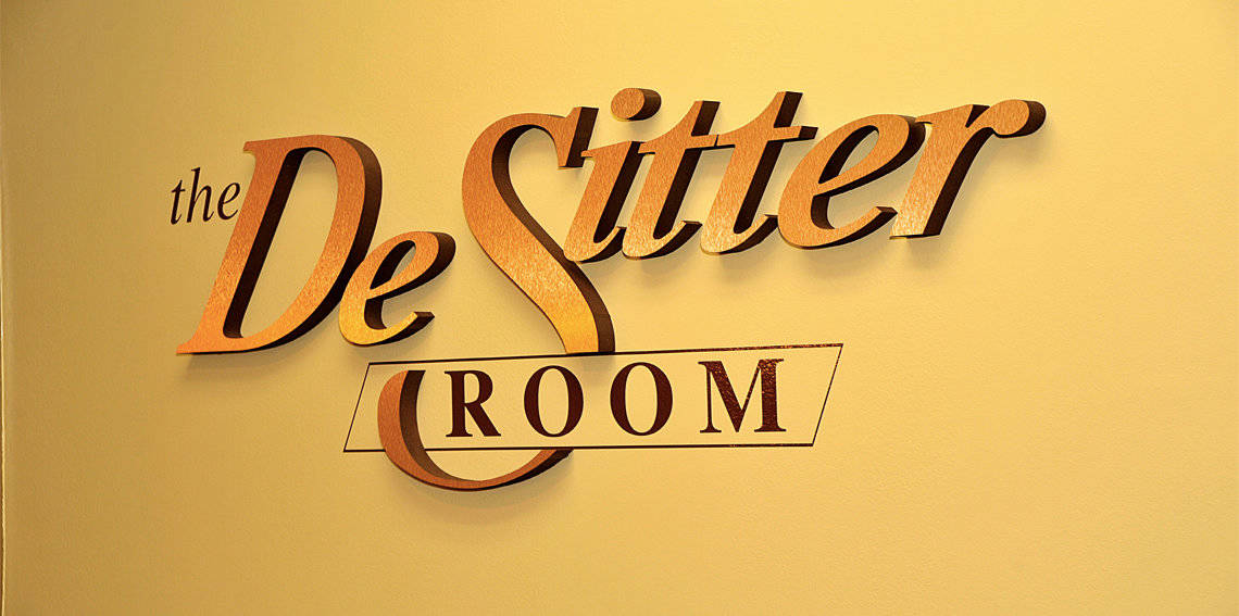 The destiter room logo on a yellow wall.